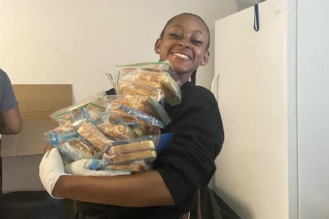 Jordine Jones with an armful of sandwiches in resealable bags.