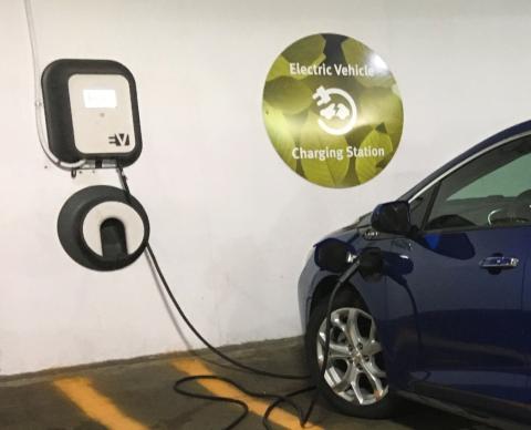 A dark blue electric car is plugged into a charger at an EV designated space in a parking structure. <a href="https://commons.wikimedia.org/wiki/File:Chevy_Volt_2nd_gen_charging_Arlington_08_2017_5216.jpg">Mariordo (Mario Roberto Durán Ortiz)</a>, <a href="https://creativecommons.org/licenses/by-sa/4.0">CC BY-SA 4.0</a>, via Wikimedia Commons