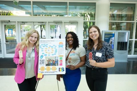 image of a student team with their poster at the Ideas to Serve event