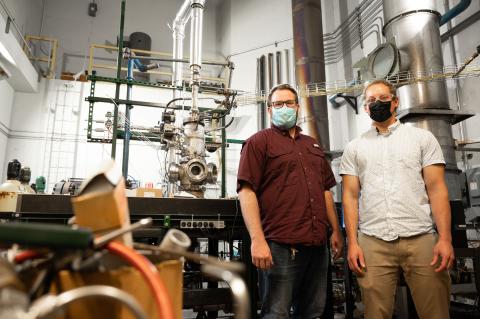 Kristopher Manion, lab manager, and Ben Emerson, research engineer stand in front of a combustion experiment at the Ben T. Zinn Combustion Lab.