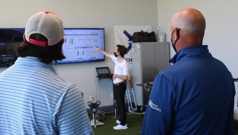 Second-year mechanical engineering student Brittan Pero talks through some of the data collected during tests of a 3D-printed putter with Tech alumni Reagan Cink, left, and his father, Stewart, a PGA Tour pro golfer. (Photo: Joshua Stewart)