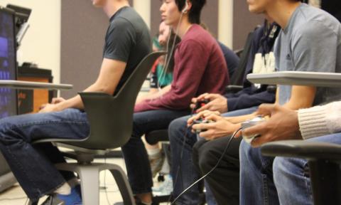Students sit at desks in a classroom playing Smash Bros.
