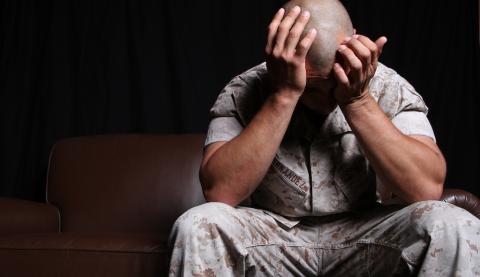 Veteran battling PTSD with head in hands