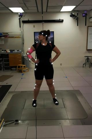 Fry dons a set of motion capture markers (illuminated dots) and electromyography (EMG) electrodes (pink bands) to participate in Drnach's human-human interaction study.
