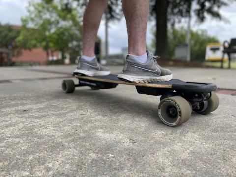 Low profile photo of a student riding a skateboard up close.