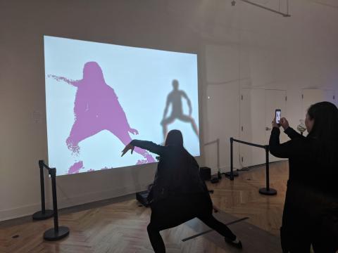 A participant at the Art plus Tech Festival in San Francisco dances with LuminAI, the interactive dance art installation created at the Georgia Institute of Technology