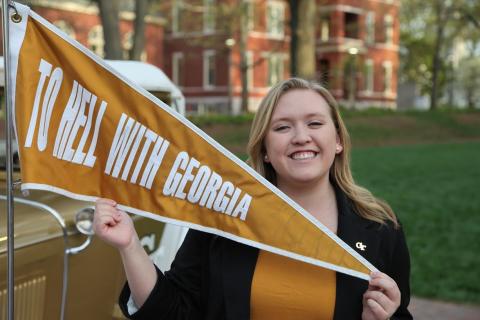 Megan Stevens poses with the "To Hell With Georgia" pennant on the Ramblin' Reck.