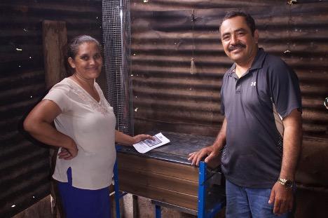 A man and a woman pose smiling with their new clean cookstove.