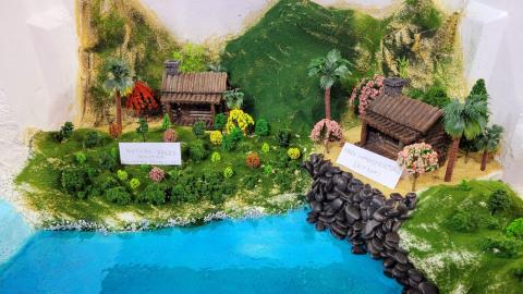 A diorama of a coastline with both a nature-based protection solution and a hard infrastructure solution.