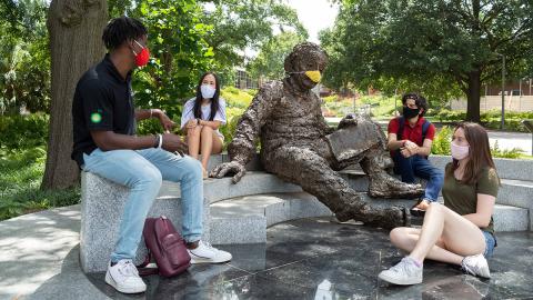 Students model appropriate safety precautions with the Einstein statue, including wearing face coverings and maintaining social distance. (Photo: Allison Carter)