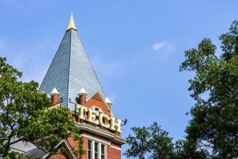 Photo of Tech Tower with a blue sky in the background and surrounded by trees.