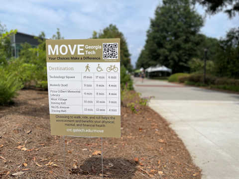 Photo of Move Georgia Tech yard sign next to a campus walking path.