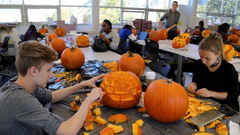 Industrial design students carve pumpkins as part of a class project.