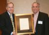 Chip White presents Joe Mello (IE 1980) with the Hill Society Award for his leadership in the healthcare industry