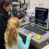 Researcher showing a child a spider on a microscope