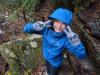 CSE Ph.D. student Xiaojing An wearing a blue raincoat making peace signs during a hike.