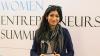 Hira Rizvi stands with an award in front of a backdrop that reads "Women's Entrepreneurship Summit."