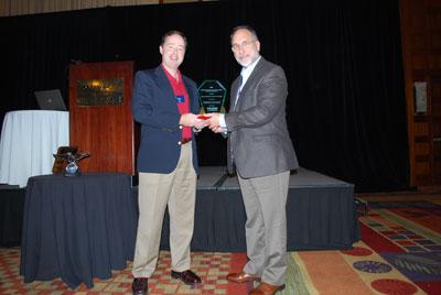 John J. Bartholdi III (right) accepts award from Mike Ogle, managing director of the College Industry Council on Material Handling Education. Not pictured is co-author Steven Hackman.