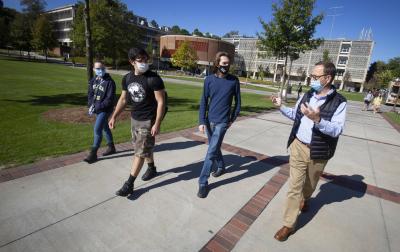 ECE Professor Bernard Kippelen (far right) walks with his students