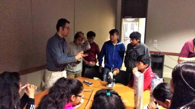 A group of students learn about pixels in backlit devices like smartphones and tablets from Mohammad Taghinejad (far left).