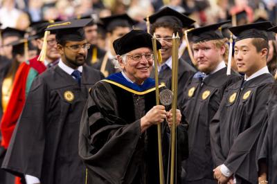 George Nemhauser carries the ceremonial mace at the Fall 2015 Commencement for Ph.D. and master&#039;s graduates. The mace, with its three brass rods, symbolizes Georgia Tech&#039;s mission and its three primary components: education, research, and service.