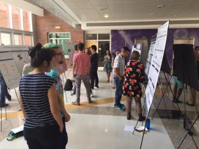 Students and faculty check out research projects of summer undergraduate research program participants during a July 26, 2017, poster session. (Photo by Renay San Miguel.)