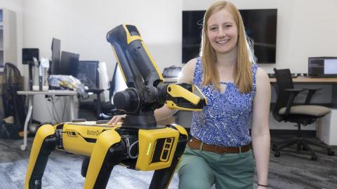 Erin Botti, a fourth-year Ph.D. student in robotics at Georgia Tech poses with four-legged robot (Photos by Terence Rushin/Colege of Computing)