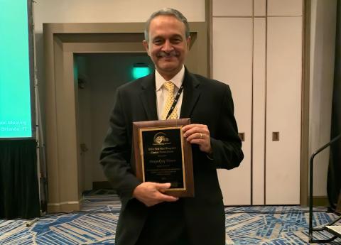 Photo of ECE Professor Deepakraj Divan holding the 2023 Nari Hingorani Custom Power Award plaque.