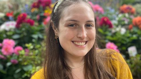 Jennifer Nicholas smiling in front of a field of flowers.