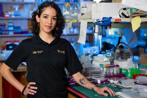 Carolina Colón stands at her bench in the lab.