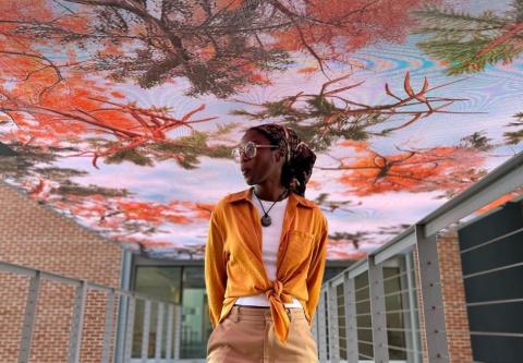 Artist Adira Griffin underneath “Gather the Forest”, an interactive art piece by Stuart Romm, Amy Landesberg, Jordan Graves, and Hudson Treu displayed on Georgia Tech’s Media Bridge. (Photo by Terence Rushin.)
