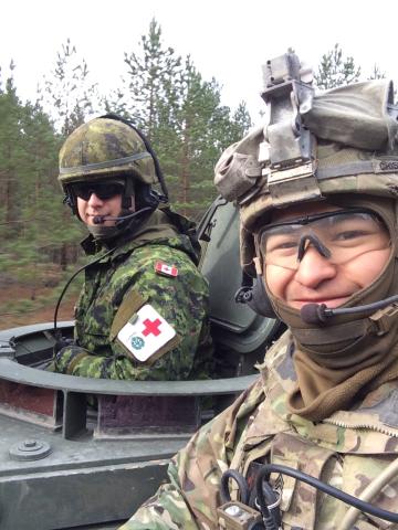 Corey Crisostomo (right) poses for a photo with a friend (left) during his service in the United States Army. Both are wearing military uniforms.