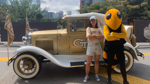 Ana Santos posing in front of the GT Wreck car with Buzz