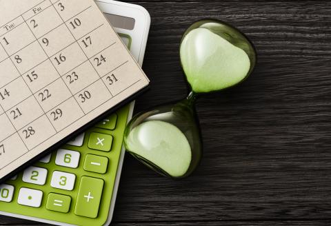 Photo of hourglass, calendar and calculator.