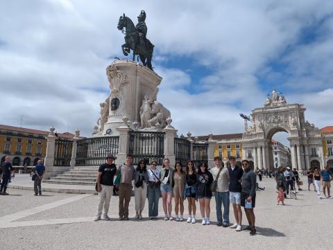 Group photo outdoors in front of statue.