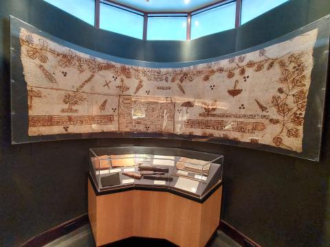 Long artwork with brown illustrations over a exhibit case