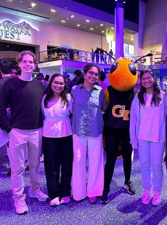 Students at the Georgia Aquarium posing with Georgia Tech mascot Buzz.