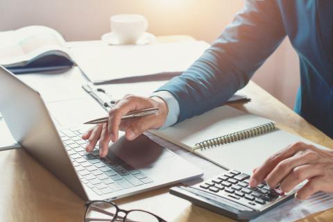 Hands at computer and calculator