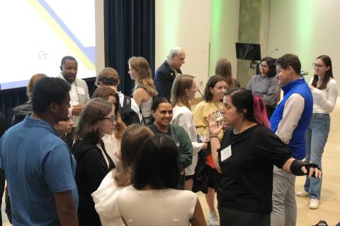 A crowd of students and alumni in an auditorium.