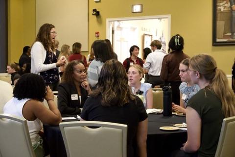 A group of people have a discussion at a round table.