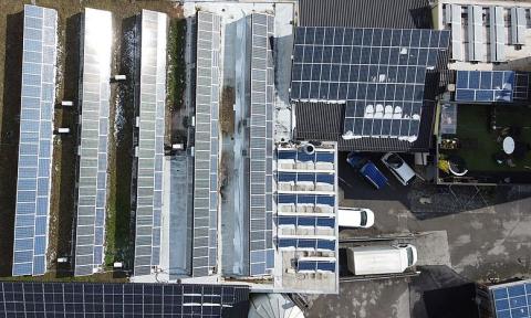 Aerial view of a commercial building with roof-mounted solar panels. Image credit: Asurnipal, CC BY-SA 4.0 <https://lnkd.in/ddzprHi>, via Wikimedia Commons