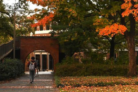 A young man crossing a brick archway at Georgia Tech.