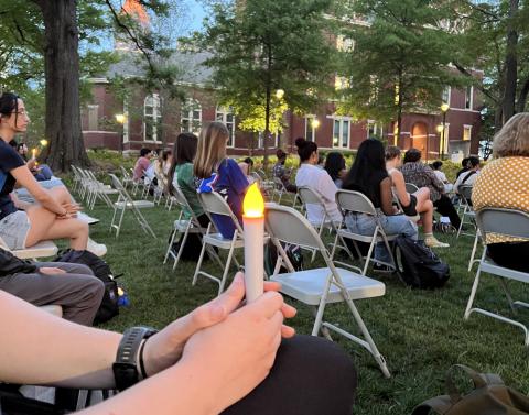 Students, faculty, and staff hold candles at Take Back the Night