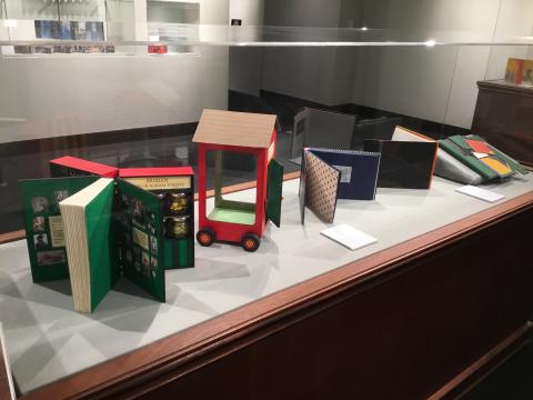 Display case with several brightly colored books open for viewing.