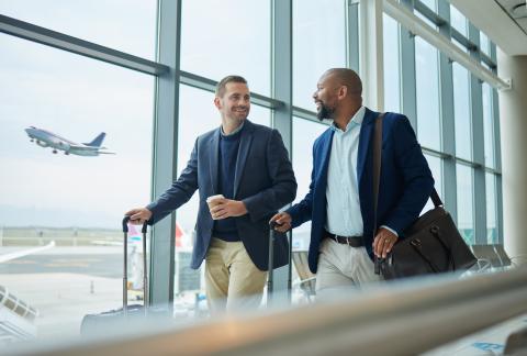 Two travelers at the airport. Plan in background taking off.