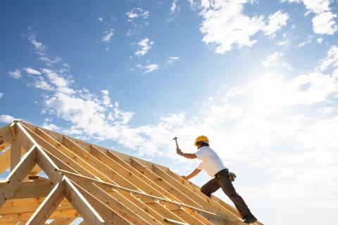 Carpenters build a roof on a residential house