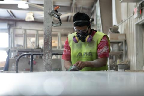 Man sanding a slab of fabricated stone.