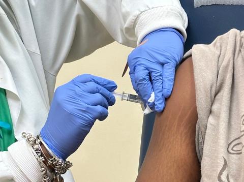 student receiving immunization from nursing staff
