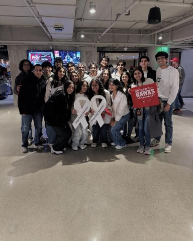 Group picture with individual holding a large white ribbon.