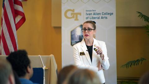 Dean Amanda Murdie speaks with an American flag and white Ivan Allen College of Liberal Arts banner in the background.